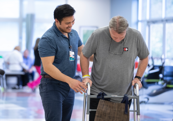 Health care worker assisting a patient using a walker