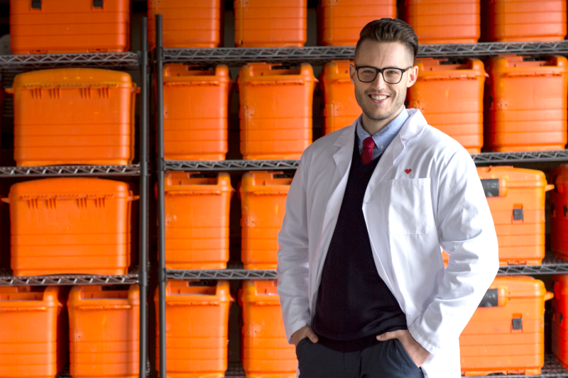 An Omnicare representative standing in front of shelves full of bins use to deliver patient medication