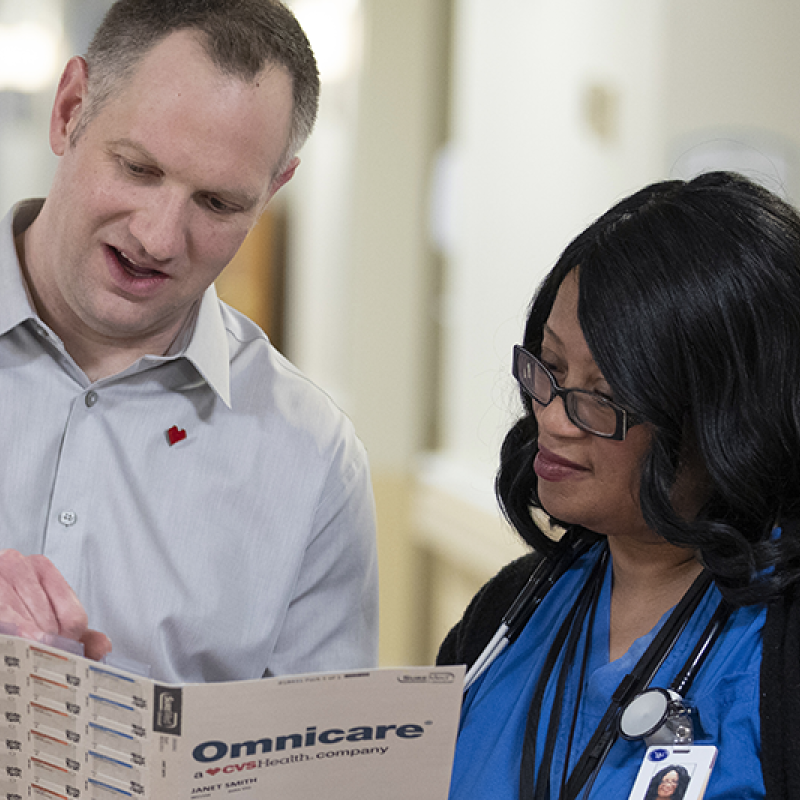 Jim Andros, Omnicare Account Manager, reviewing a patient's medication record with a resident care facility staff member